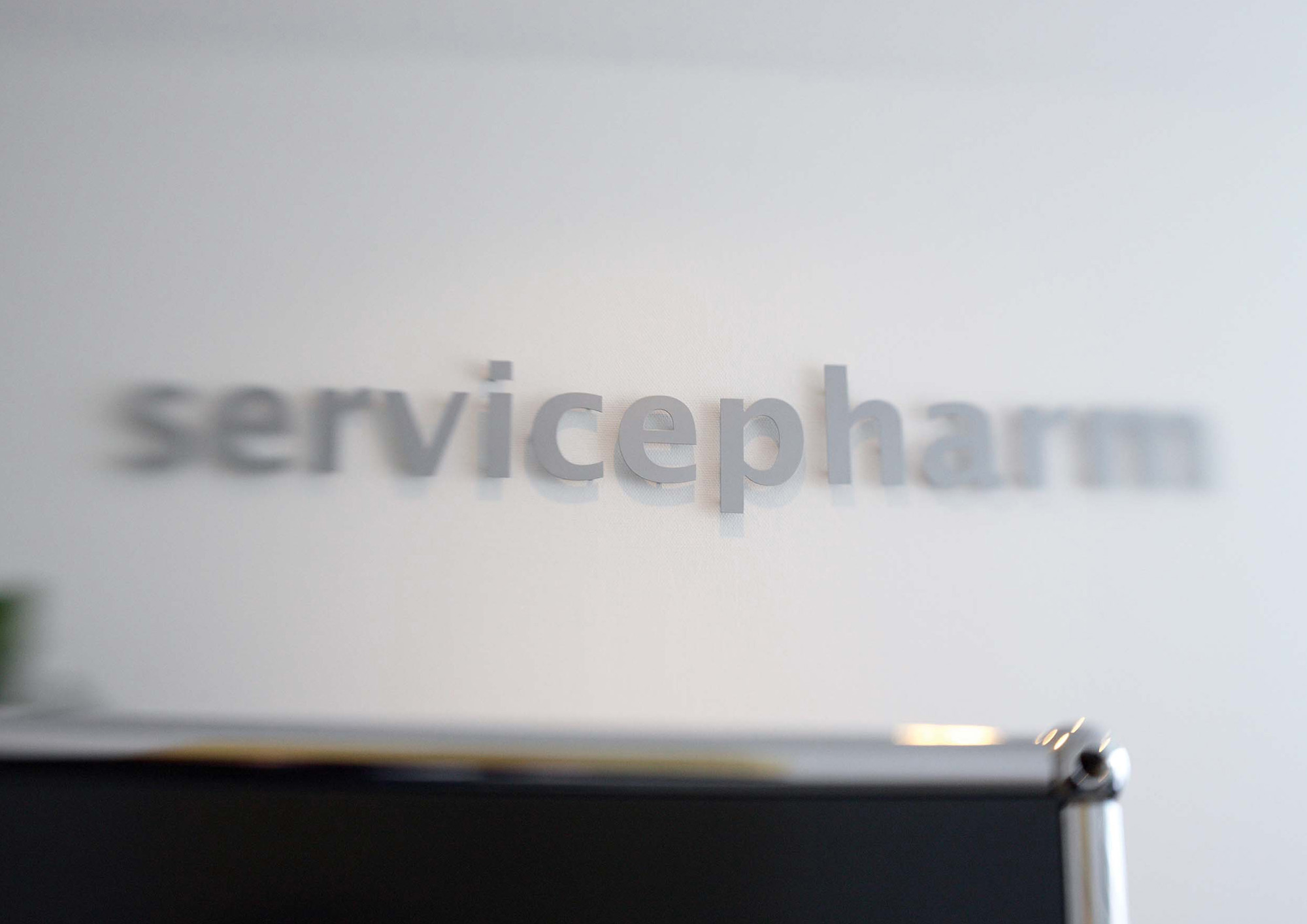 Detailbild zeigt das Servicepharm Lettershop Logo im Besprechungsraum